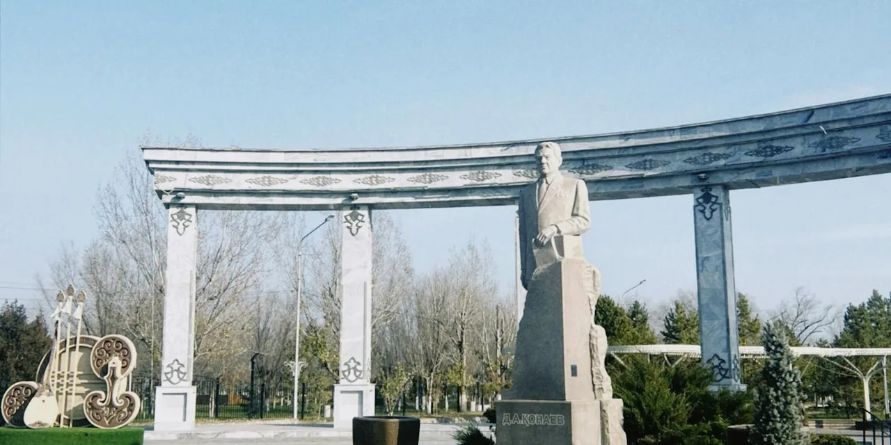 Statue surrounded by architectural arch in Konaev, Almaty Region, Kazakhstan.