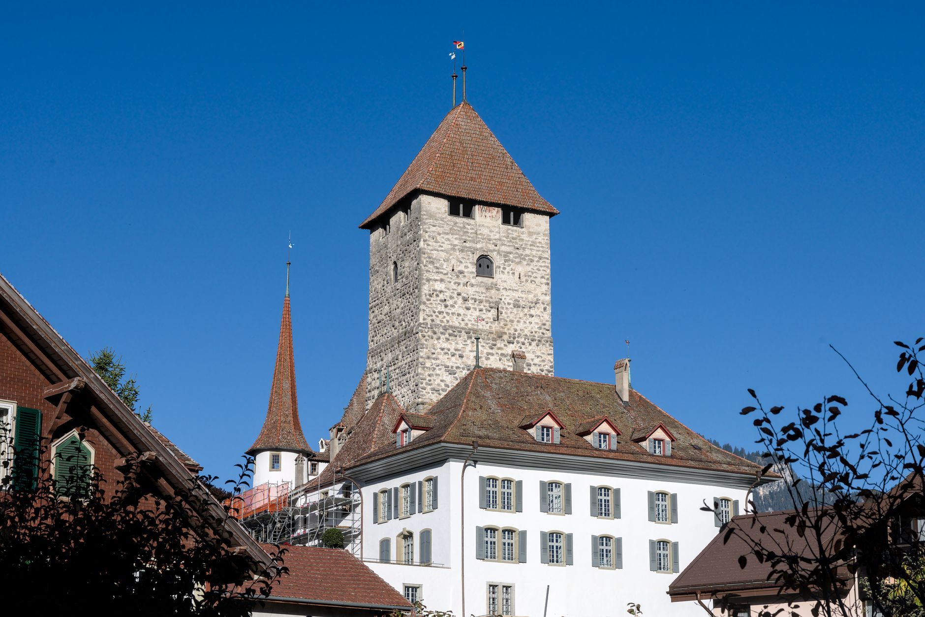 Capture of the historic Spiez Castle with a vibrant blue sky background in Switzerland.