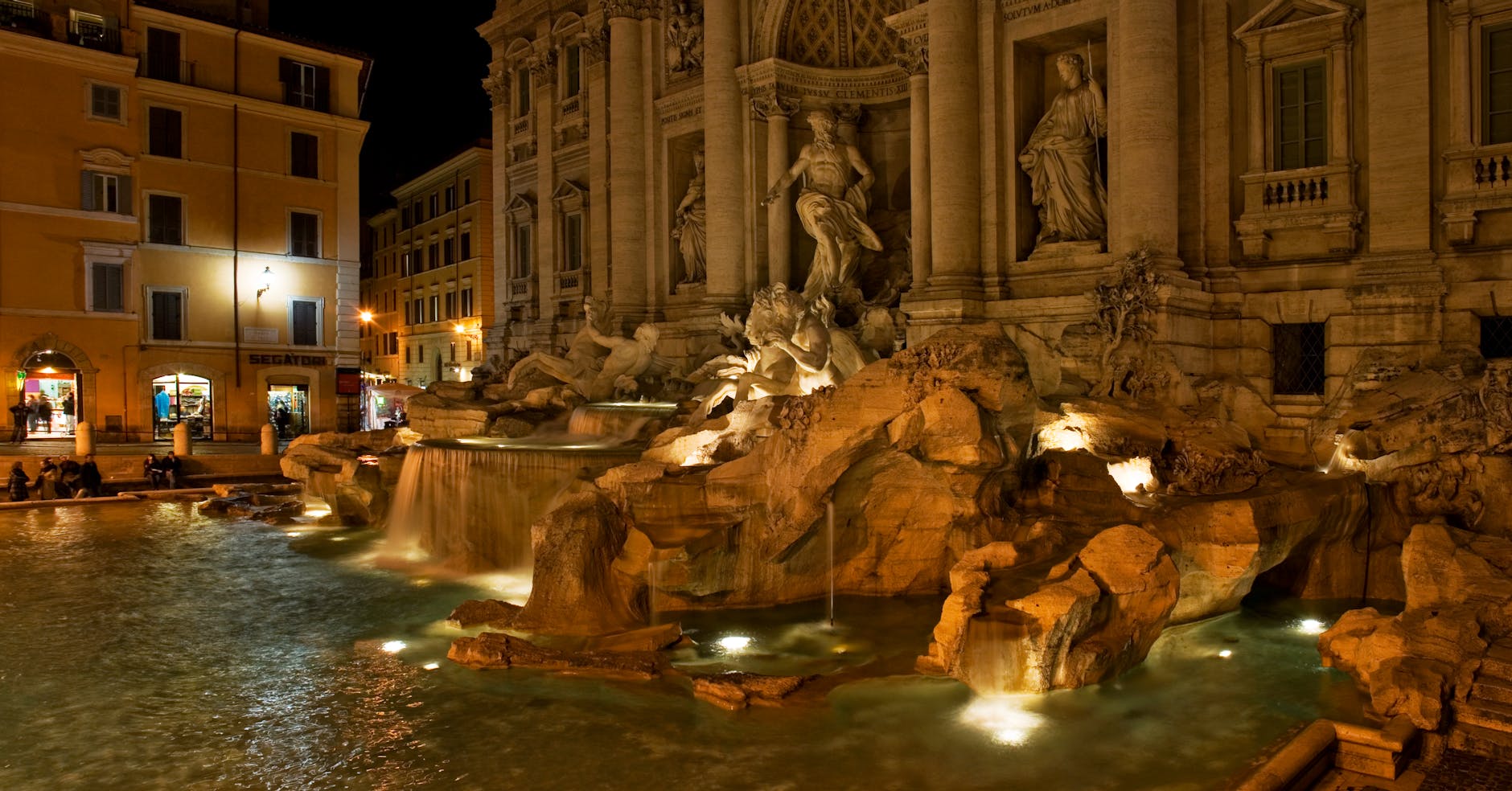 The iconic Trevi Fountain illuminated at night, showcasing its stunning Baroque architecture.