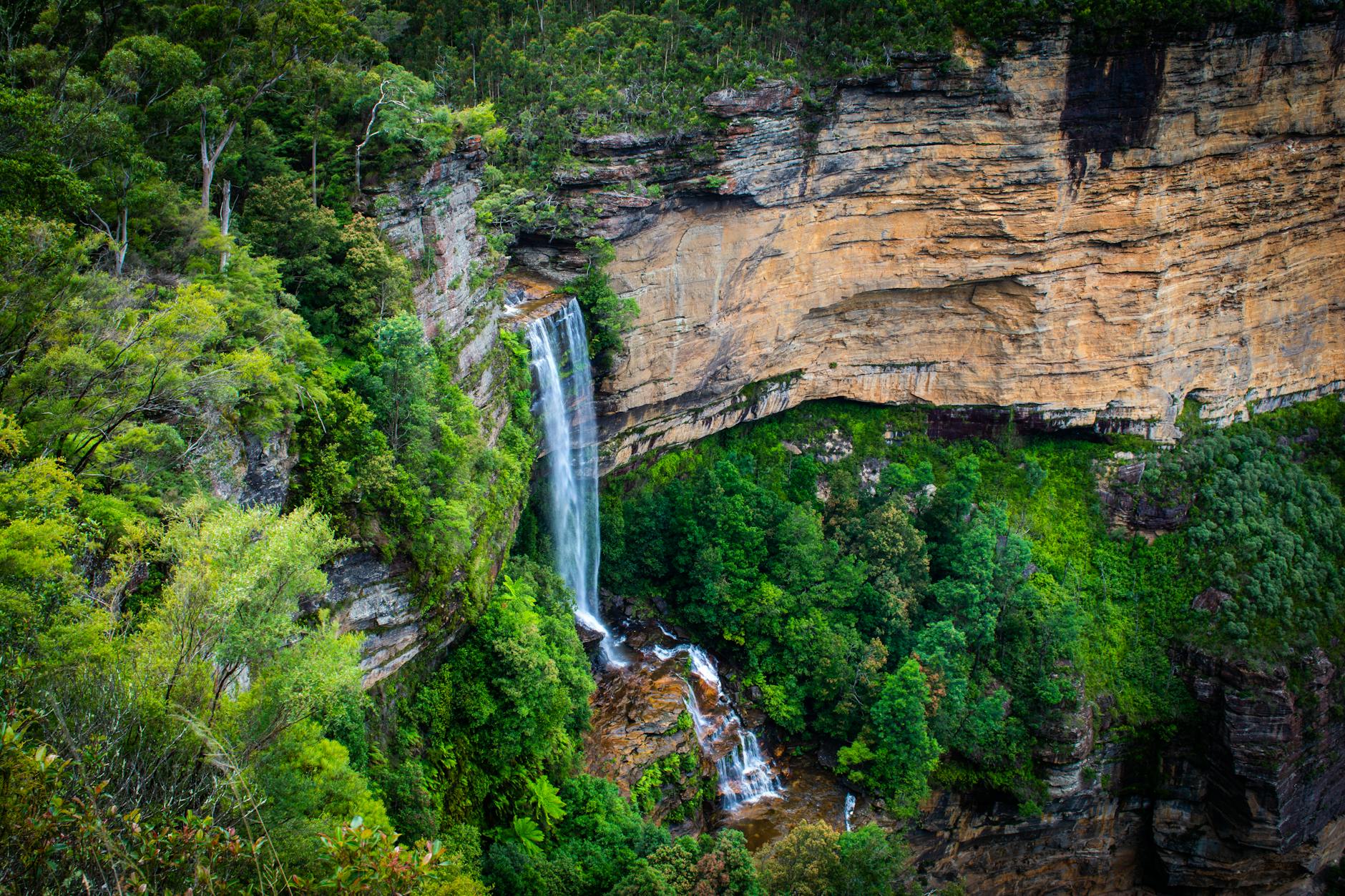 Spectacular waterfall cascading over sandstone cliffs in the lush Blue Mountains, Australia.