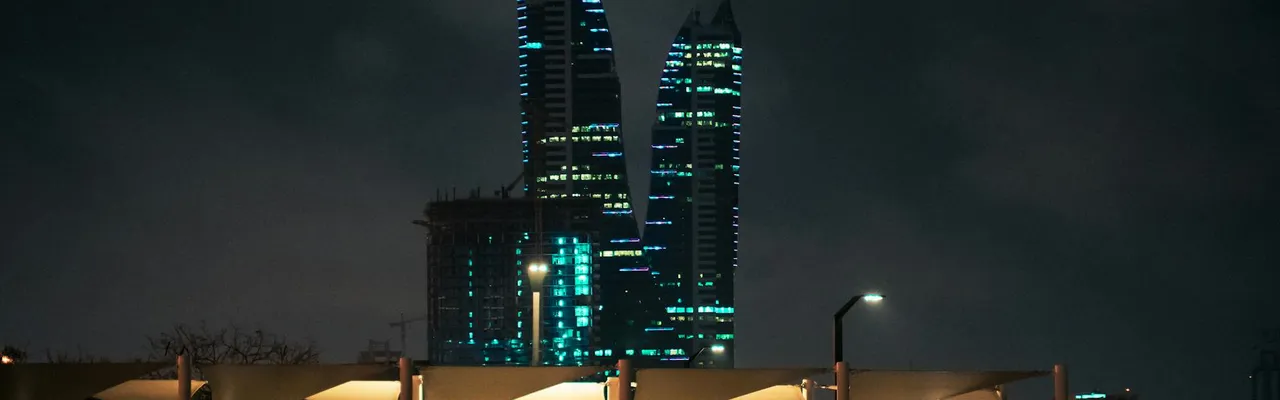 Stunning night view of Bahrain's skyline with illuminated modern towers and cityscape.