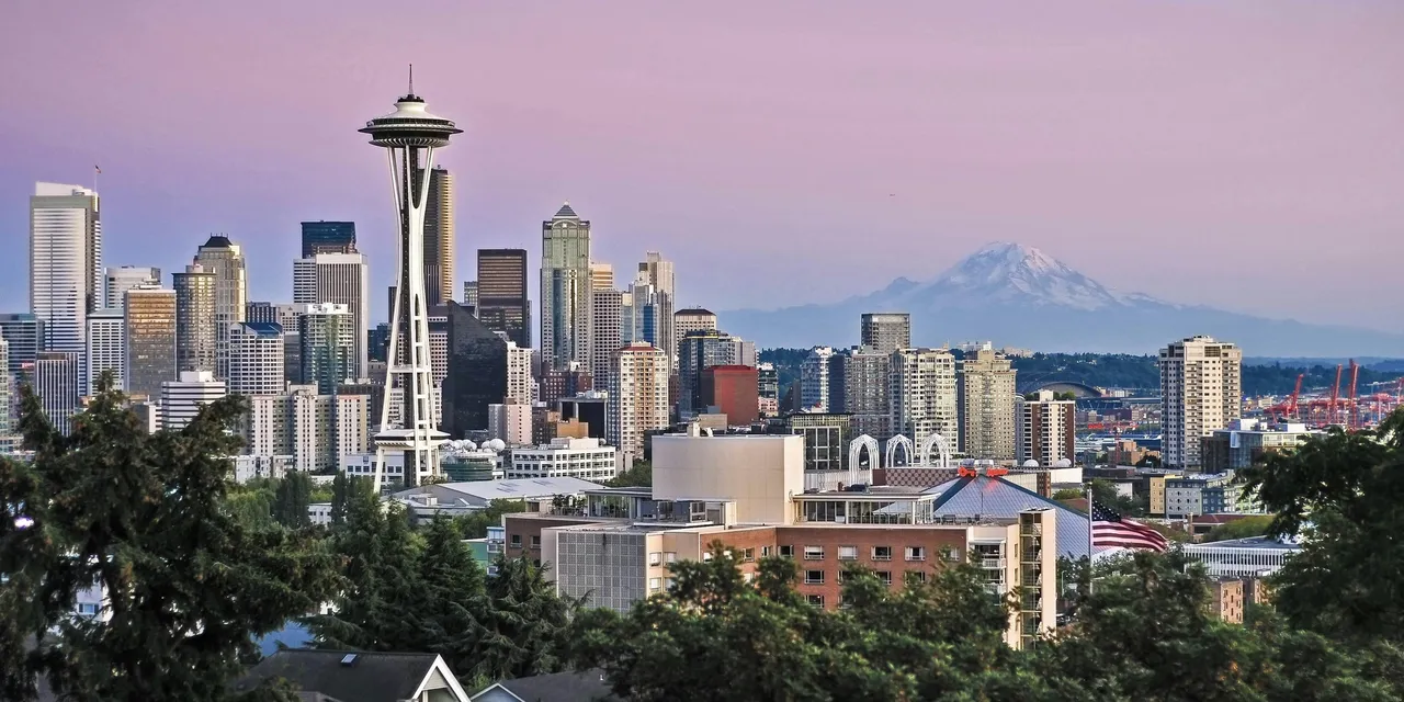 Seattle skyline with the Space Needle and Mount Rainier at sunset, United States