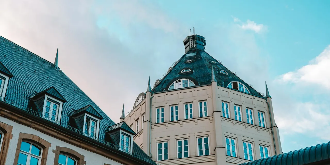 A historic building in Luxembourg stands against a striking blue sky, showcasing its unique architecture.