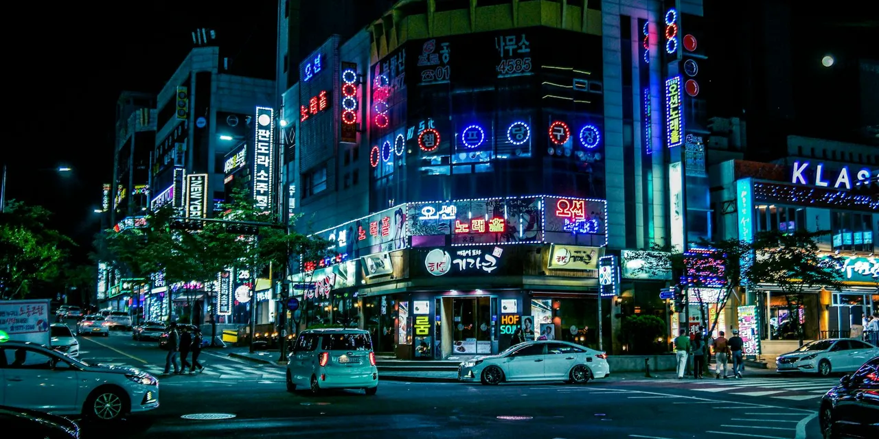 Illuminated street in Gwangju, South Korea, showcasing neon lights and city hustle at night.