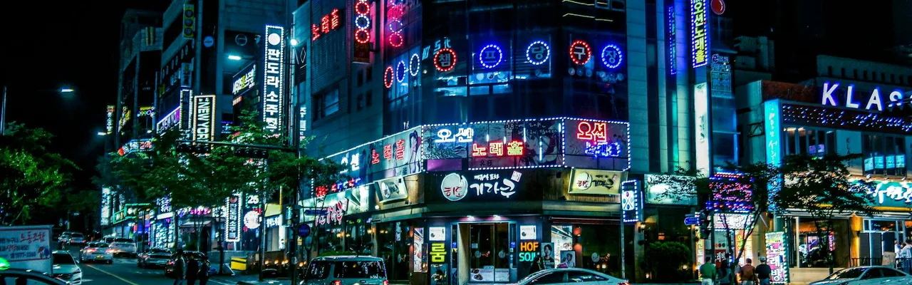 Illuminated street in Gwangju, South Korea, showcasing neon lights and city hustle at night.
