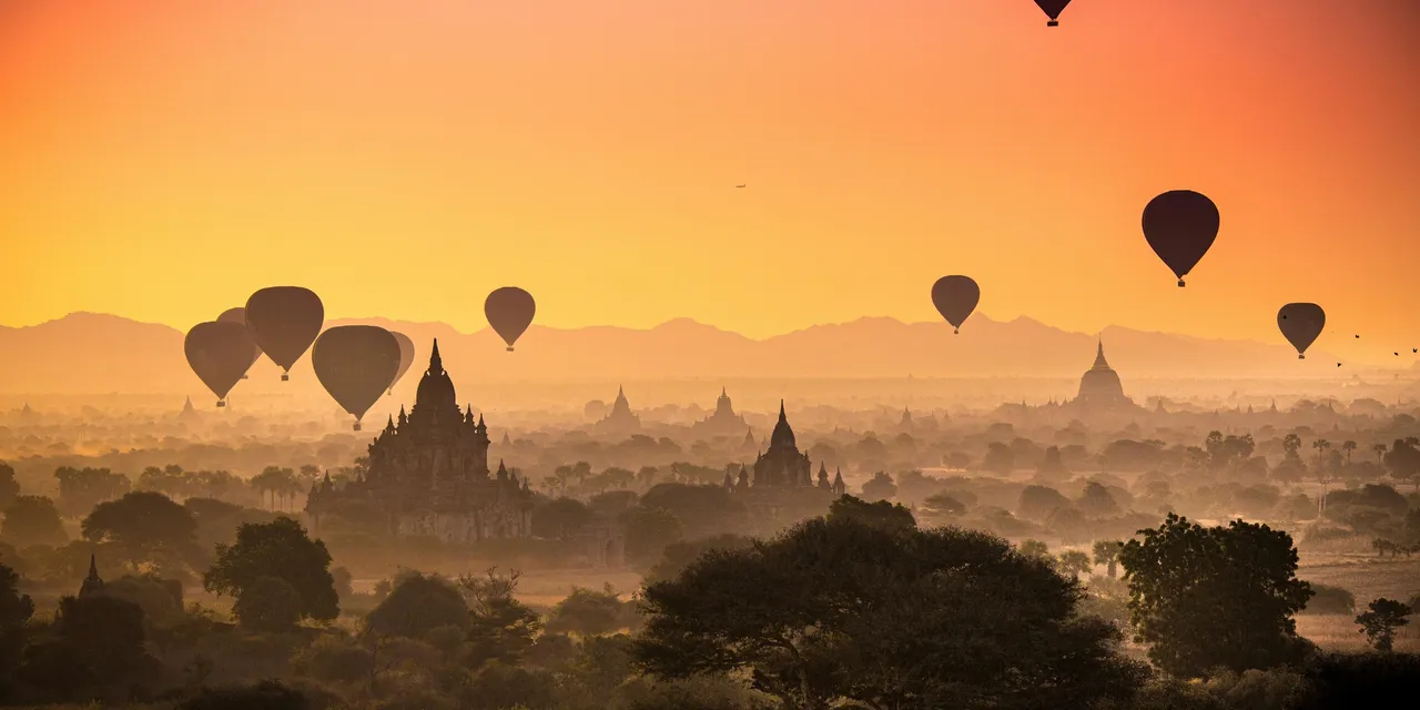 Hot air balloons drifting over the ancient temples of Bagan at sunrise, Myanmar