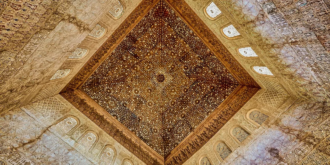 Intricately carved ceiling at Alhambra, showcasing Moorish design in Andalusia, Spain.