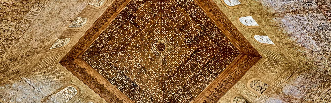 Intricately carved ceiling at Alhambra, showcasing Moorish design in Andalusia, Spain.
