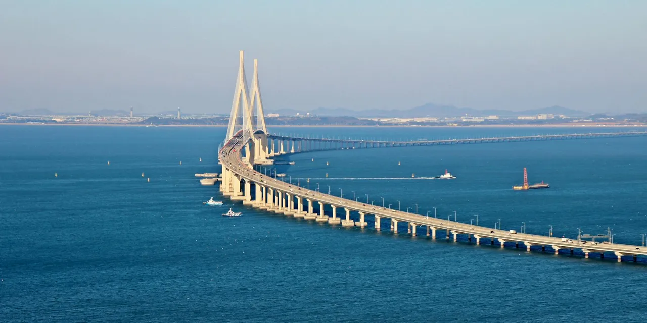 Stunning aerial view of Incheon Bridge spanning across blue ocean waters under a clear sky.