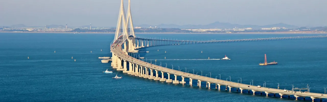 Stunning aerial view of Incheon Bridge spanning across blue ocean waters under a clear sky.