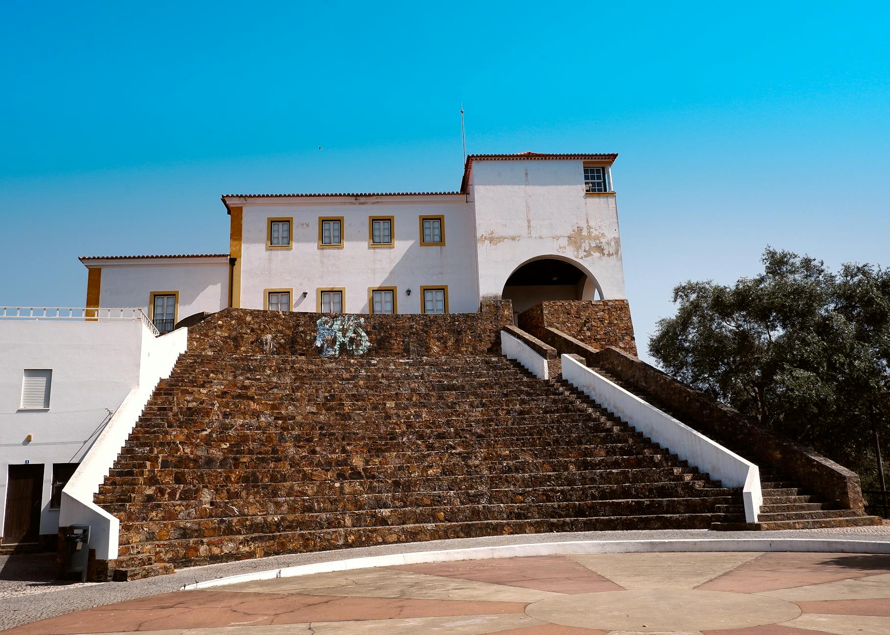 Elevated view of traditional Portuguese architecture in Odemira, Portugal under a clear blue sky.