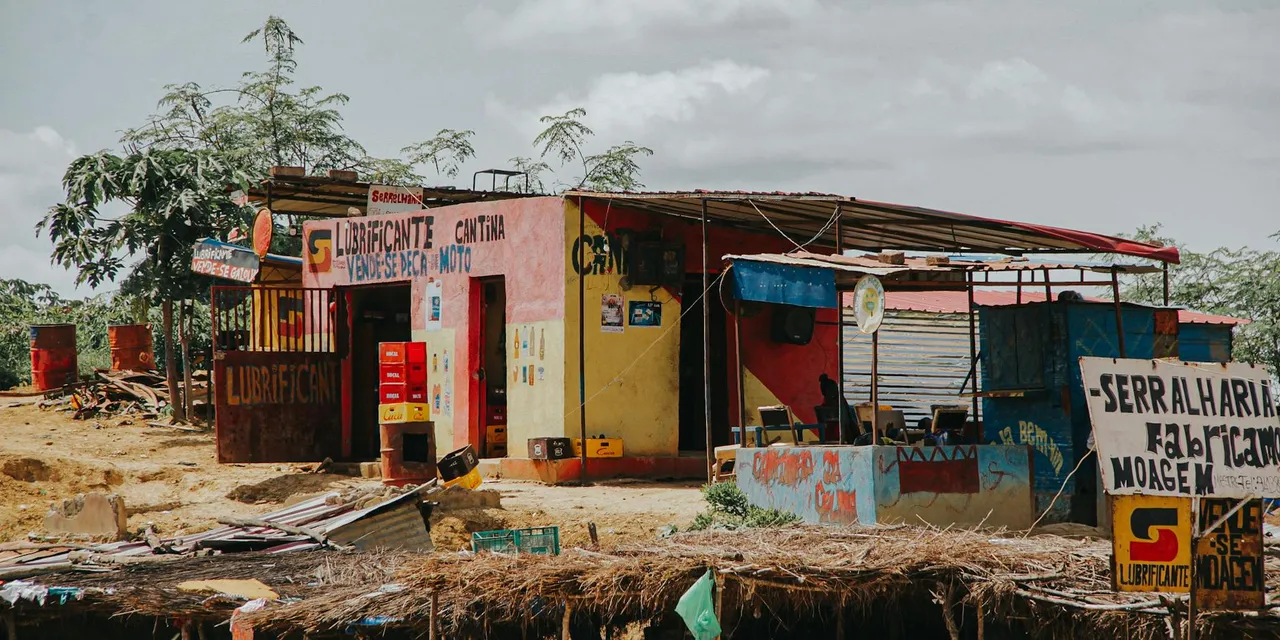 A rustic lubricant shop and cantina in rural Luanda, Angola, captured on a sunny day.
