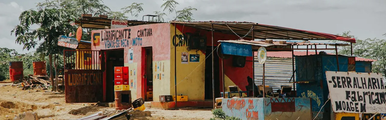 A rustic lubricant shop and cantina in rural Luanda, Angola, captured on a sunny day.