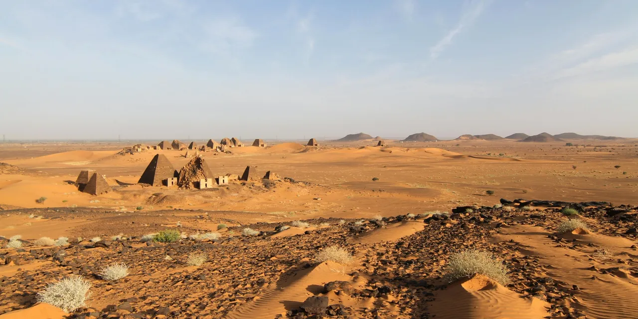 Ancient Nubian pyramids of Meroe rising from golden desert sands, Sudan