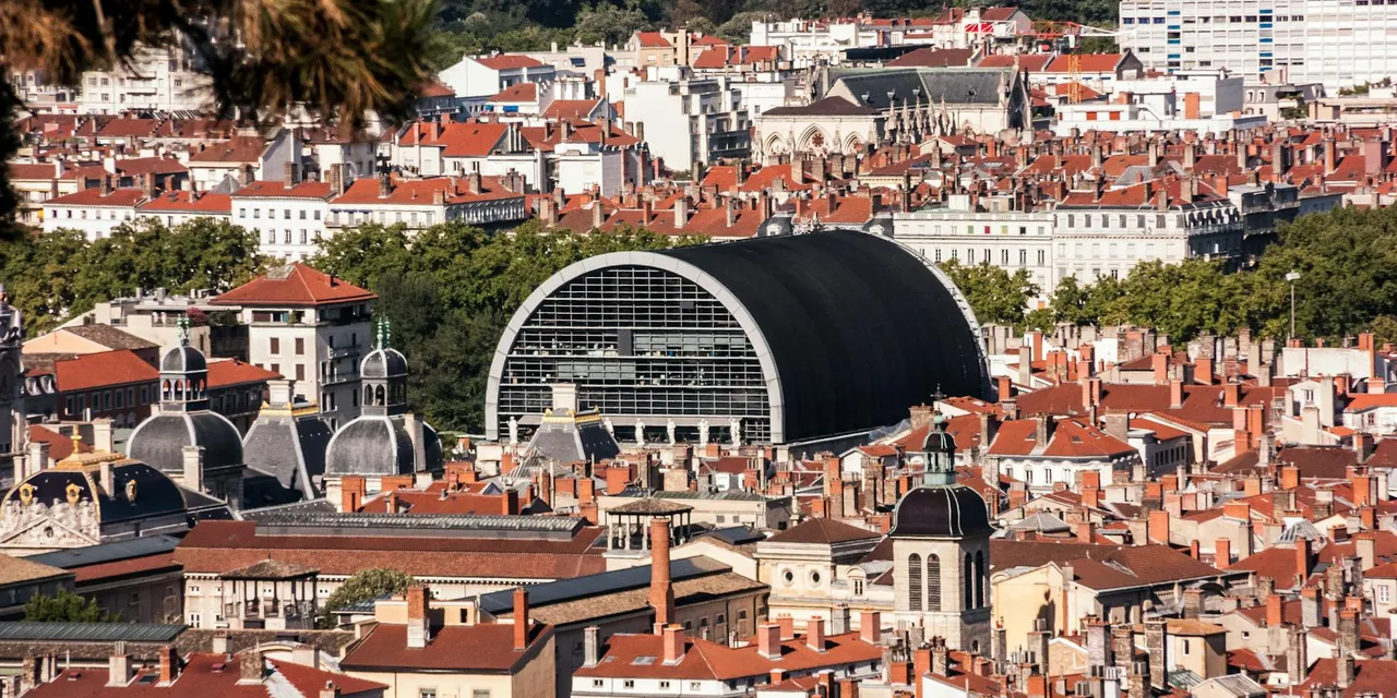 Explore a vibrant aerial view of Lyon, France, showcasing historic rooftops and unique architecture.