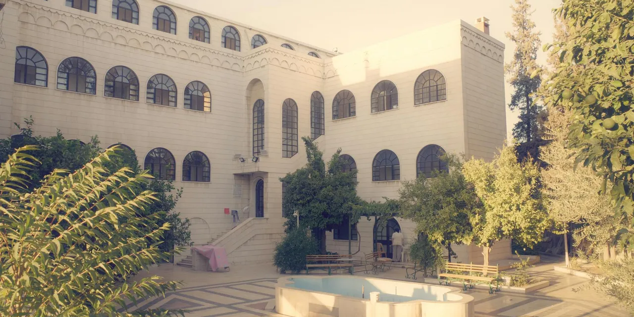 A beautiful architectural structure featuring arched windows and an open courtyard in Damascus, Syria.
