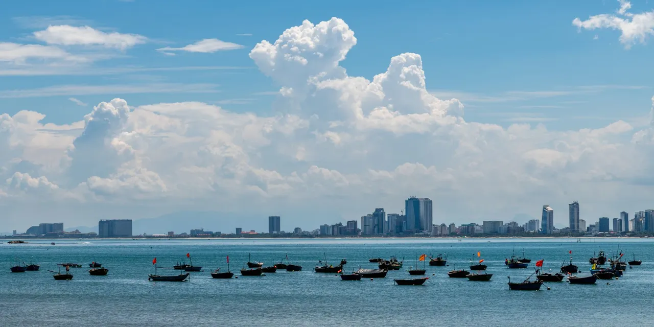 Beautiful view of Da Nang cityscape with boats in the foreground on a sunny day.