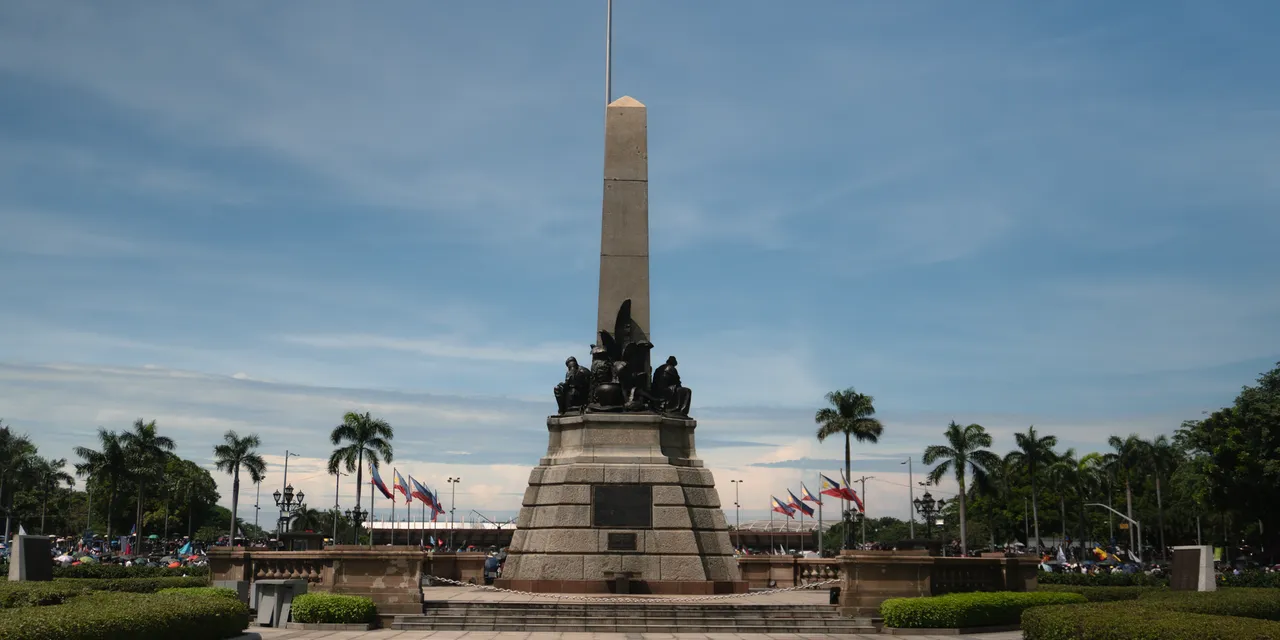 The iconic Rizal Monument in Rizal Park, Manila, under a clear sky.