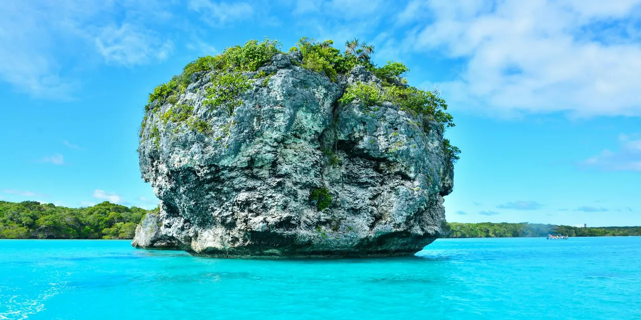 Vibrant turquoise waters and lush rock formations in Nouméa, New Caledonia.