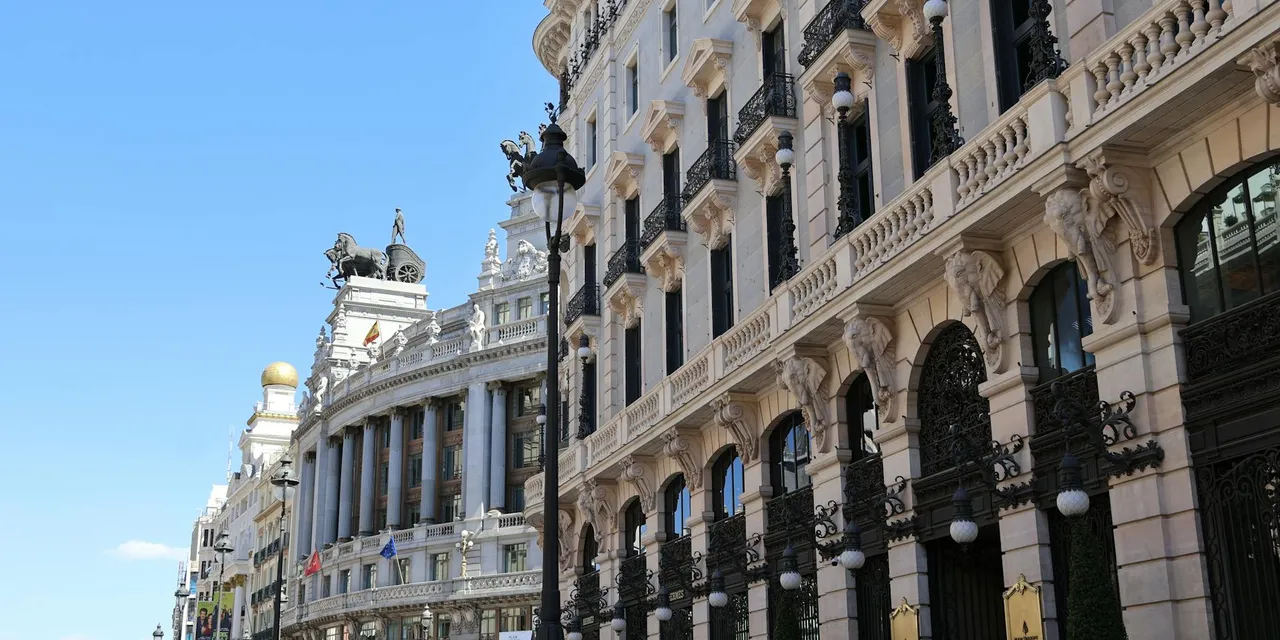 Beautiful architectural buildings in Madrid under a bright blue sky.