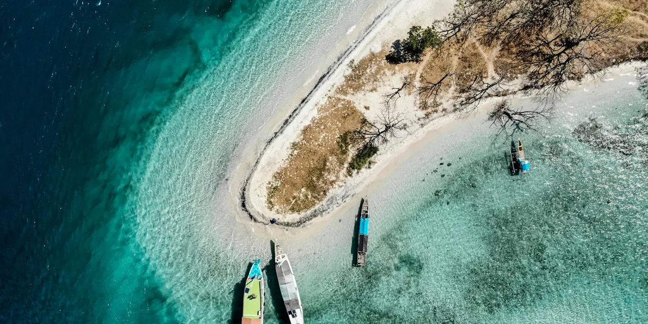 A stunning aerial view of Comoros island coastline with boats in turquoise waters.