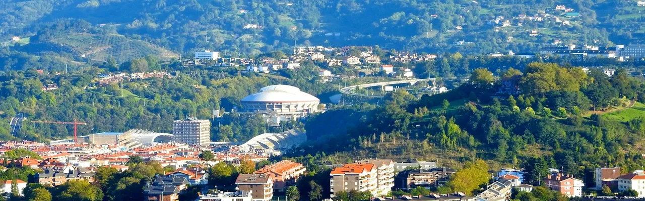 Aerial view of Donostia-San Sebastián with scenic hills and city buildings.