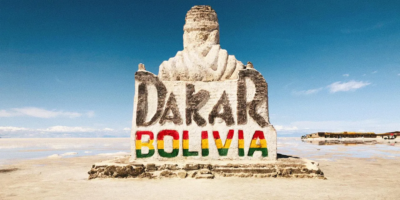 Stone monument at Salar de Uyuni celebrating the Dakar Rally in Bolivia's remote desert landscape.