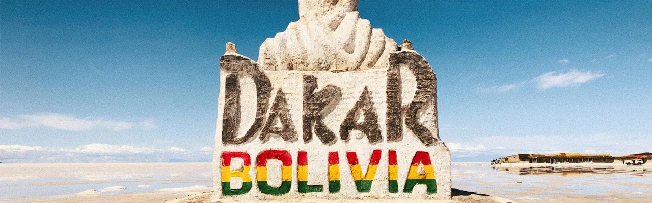 Stone monument at Salar de Uyuni celebrating the Dakar Rally in Bolivia's remote desert landscape.