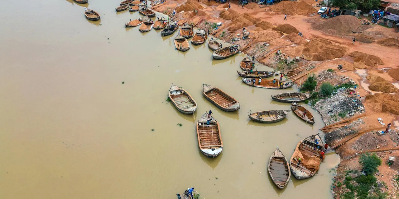 Aerial view of wooden boats along the Niger River in Bamako, Mali. Busy riverbank activity.