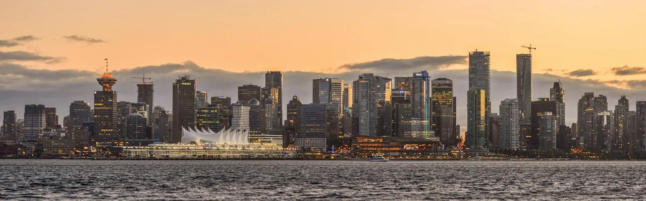 Stunning view of Vancouver's downtown skyline with waterfront and sunset glow.