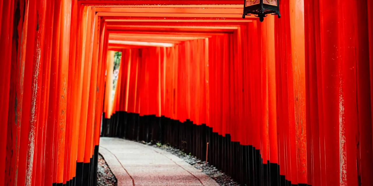 Explore the iconic red torii gates of Fushimi Inari Shrine in Kyoto, Japan, featuring traditional architecture.