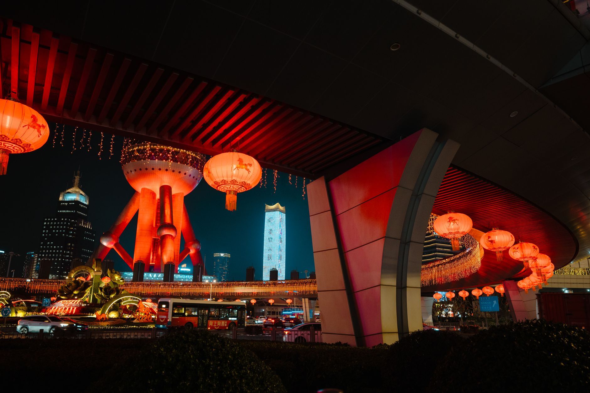 Captivating view of Shanghai's Oriental Pearl Tower at night with red lanterns lighting up the scene.