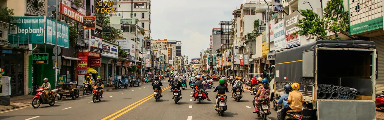 Motorcyclists navigating busy street in vibrant Ho Chi Minh City.