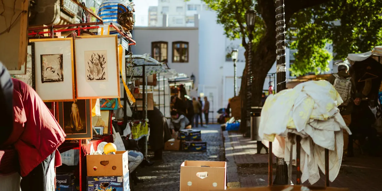 A bustling outdoor street market in Buenos Aires with art and goods on display.