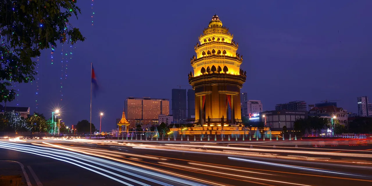 Long exposure night photograph of the illuminated Independence Monument with light streaks in Phnom Penh, Cambodia.