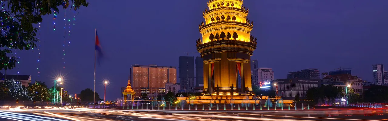 Long exposure night photograph of the illuminated Independence Monument with light streaks in Phnom Penh, Cambodia.