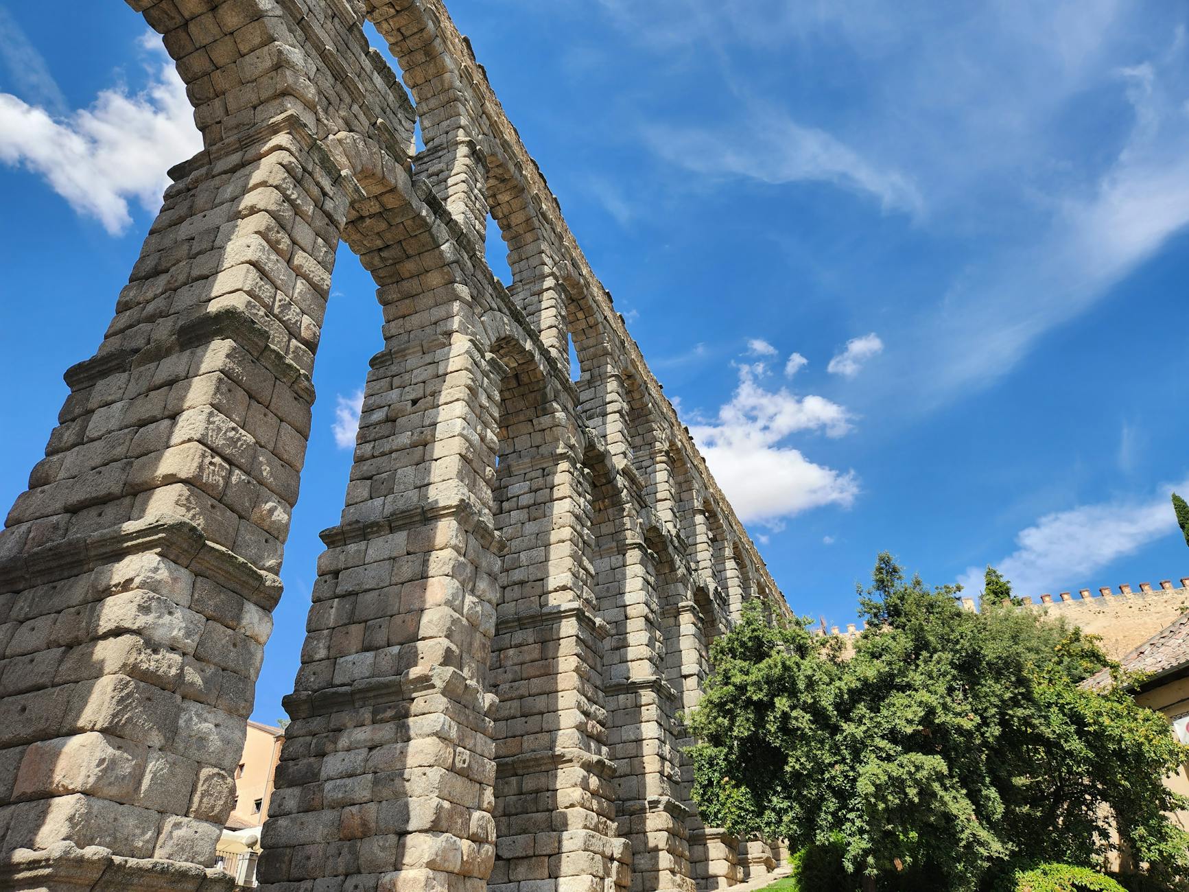 Majestic Roman aqueduct in Segovia under a clear blue sky on a sunny day.