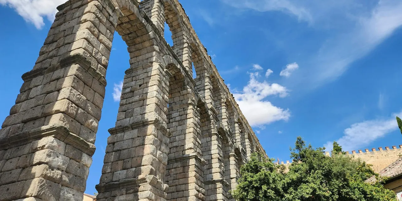 Majestic Roman aqueduct in Segovia under a clear blue sky on a sunny day.
