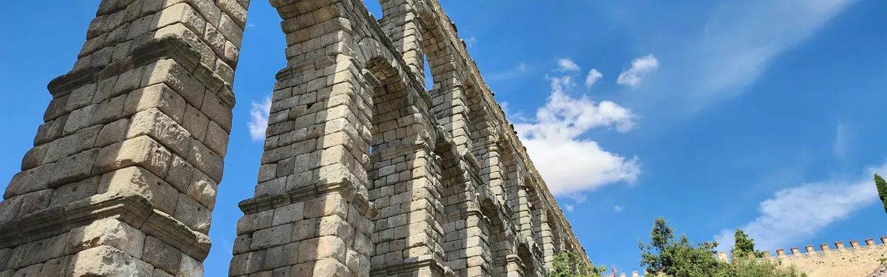 Majestic Roman aqueduct in Segovia under a clear blue sky on a sunny day.