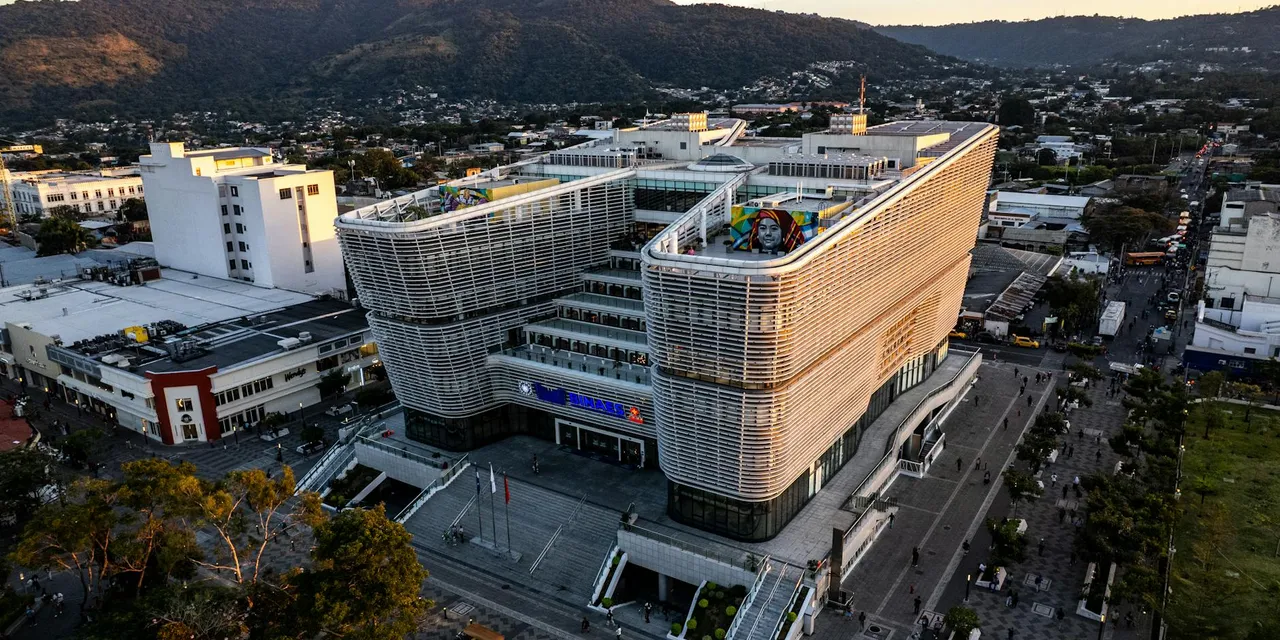Aerial view of a modern library amidst cityscape in San Salvador, El Salvador at sunset.