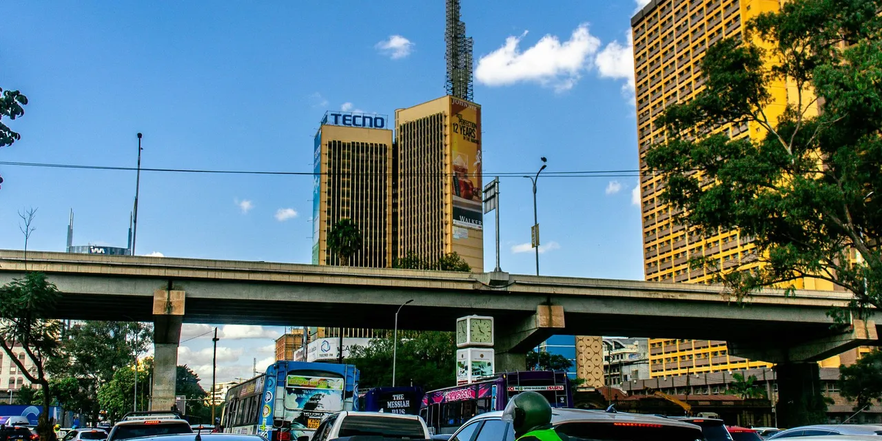 Street scene with traffic and tall buildings in Nairobi, Kenya on a clear day.