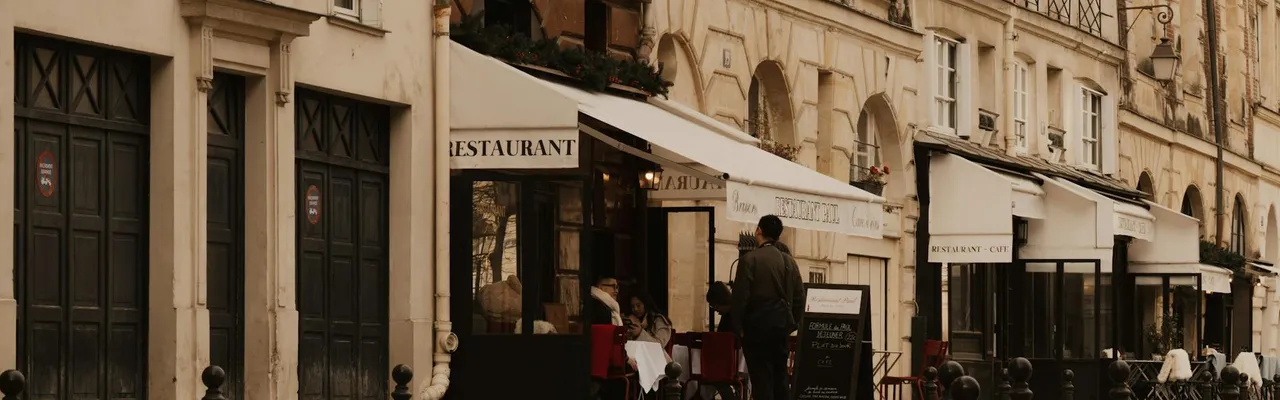 Cobblestone street in Paris with cafes and classic architecture, evoking a vintage urban mood.