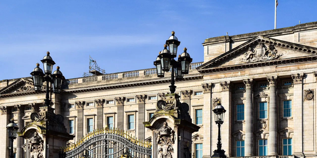 Exterior view of Buckingham Palace in London showcasing its historic architecture and ornate gate.