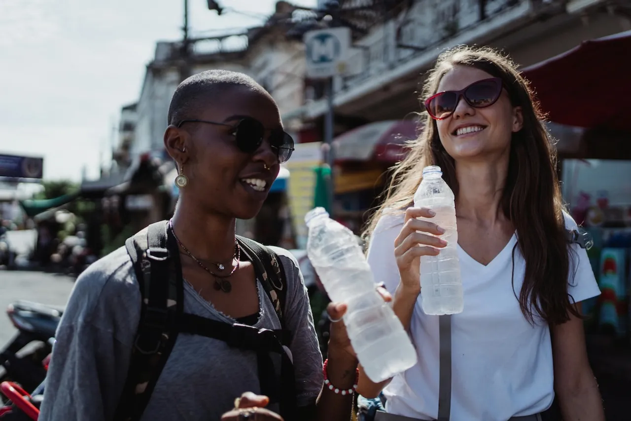Young female travellers with IBD drinking bottled water in India