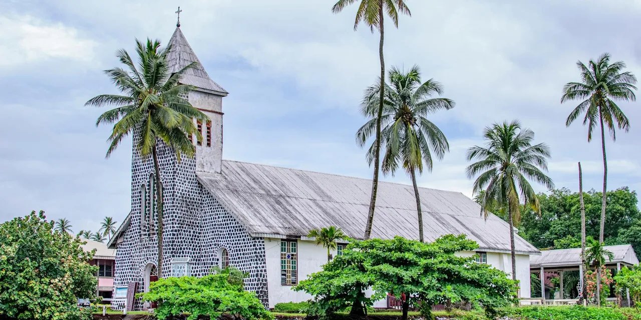Historic stone church, tropical palm trees in Limbe, Cameroon.