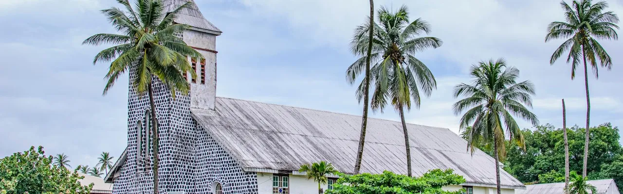 Historic stone church, tropical palm trees in Limbe, Cameroon.