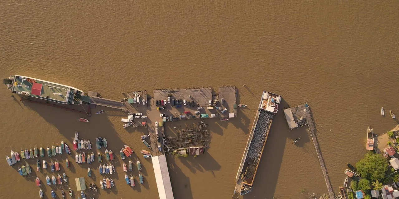 Aerial shot of Parika dock in Guyana showing boats and piers on the Essequibo River.