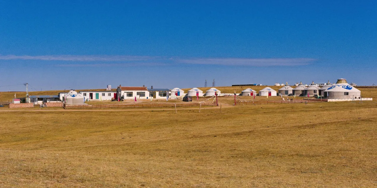 Scenic view of a traditional settlement with yurts in the vast grasslands of Inner Mongolia, China.