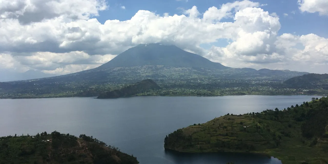Beautiful landscape of a lake with mountains under a cloudy sky in Butaro, Rwanda.