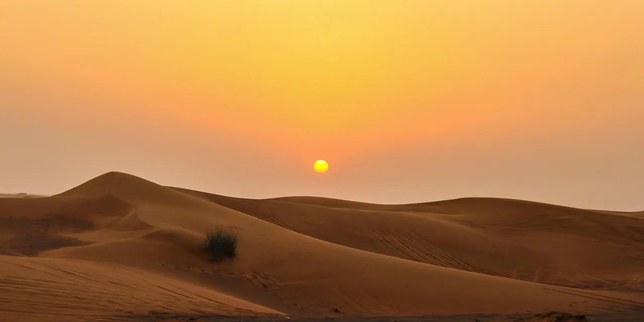 Stunning view of golden sand dunes and sunset in Dubai desert.